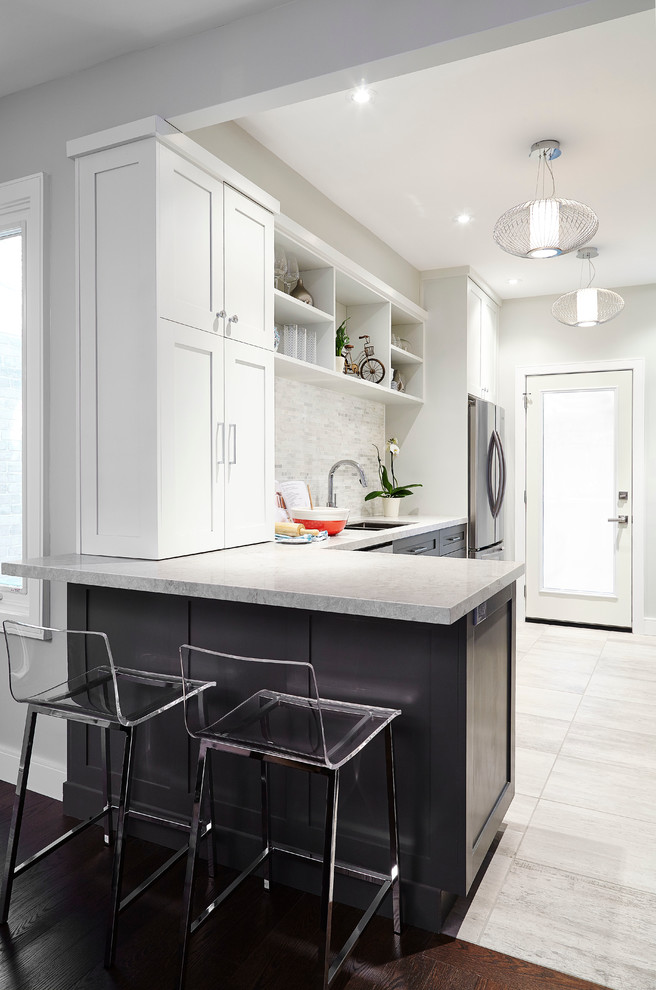 Inspiration for a large contemporary u-shaped eat-in kitchen in Toronto with a double-bowl sink, shaker cabinets, white cabinets, marble benchtops, grey splashback, limestone splashback, stainless steel appliances, marble floors and white floor.