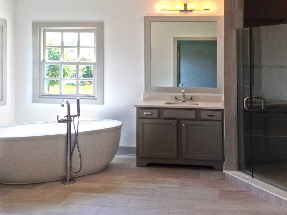 This is an example of a large contemporary master bathroom in Columbus with flat-panel cabinets, light wood cabinets, a freestanding tub, an alcove shower, a one-piece toilet, beige tile, terra-cotta tile, grey walls, terra-cotta floors, a drop-in sink and quartzite benchtops.