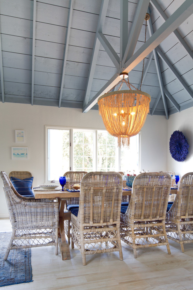 This is an example of a beach style dining room in San Diego with white walls and light hardwood floors.