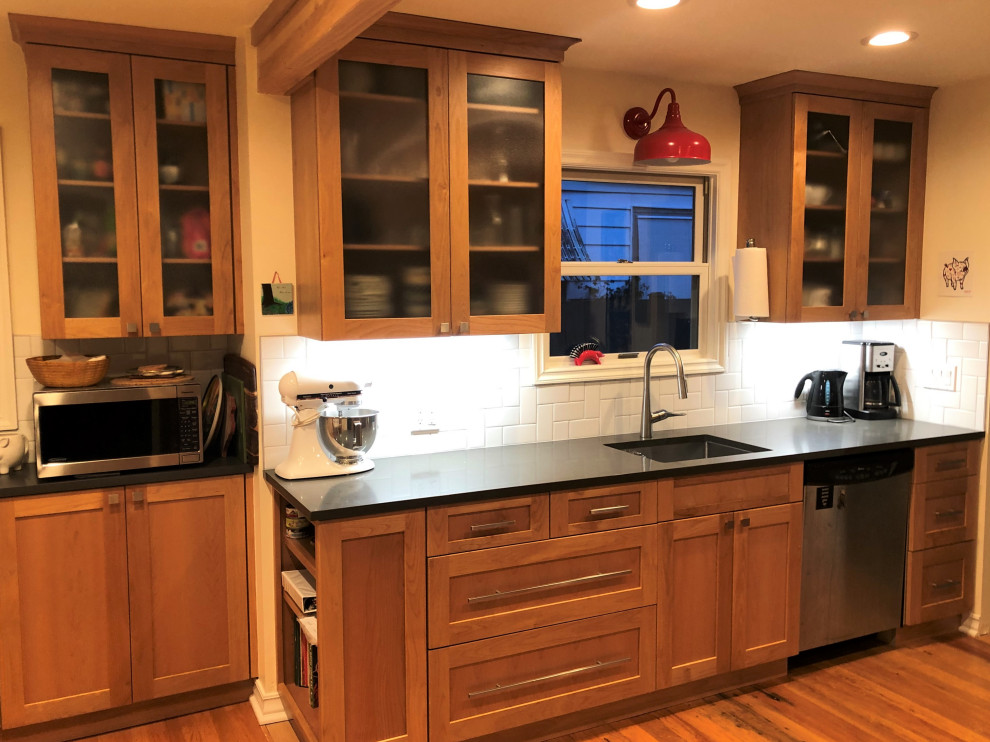 Inspiration for a mid-sized transitional galley medium tone wood floor, brown floor and exposed beam eat-in kitchen remodel in Seattle with an undermount sink, shaker cabinets, medium tone wood cabinets, quartz countertops, white backsplash, subway tile backsplash, stainless steel appliances, a peninsula and gray countertops