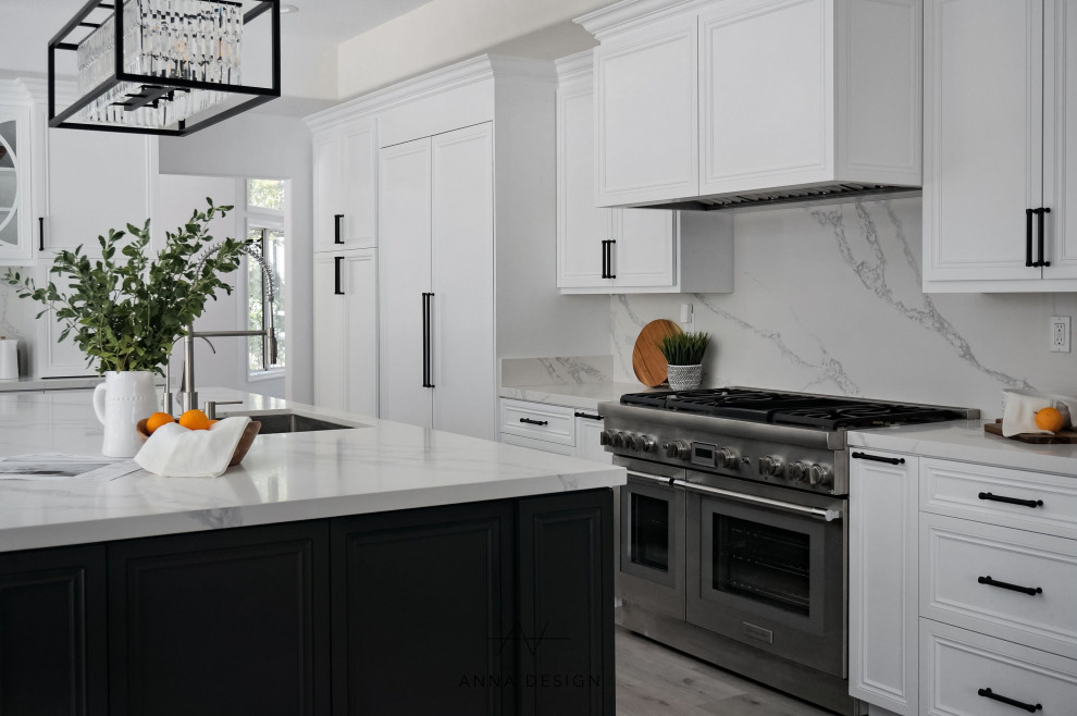 Inspiration for a large transitional l-shaped open plan kitchen in Los Angeles with a drop-in sink, louvered cabinets, white cabinets, quartzite benchtops, white splashback, engineered quartz splashback, stainless steel appliances, light hardwood floors, with island, grey floor and white benchtop.