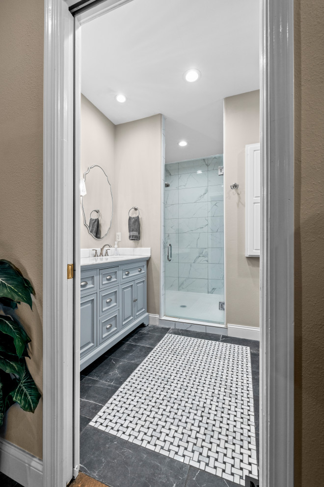 Источник вдохновения для домашнего уюта: главная ванная комната в классическом стиле с фасадами с выступающей филенкой, серыми фасадами, душем в нише, унитазом-моноблоком, белой плиткой, мраморной плиткой, бежевыми стенами, полом из керамогранита, врезной раковиной, мраморной столешницей, черным полом, душем с распашными дверями, белой столешницей, тумбой под две раковины и напольной тумбой