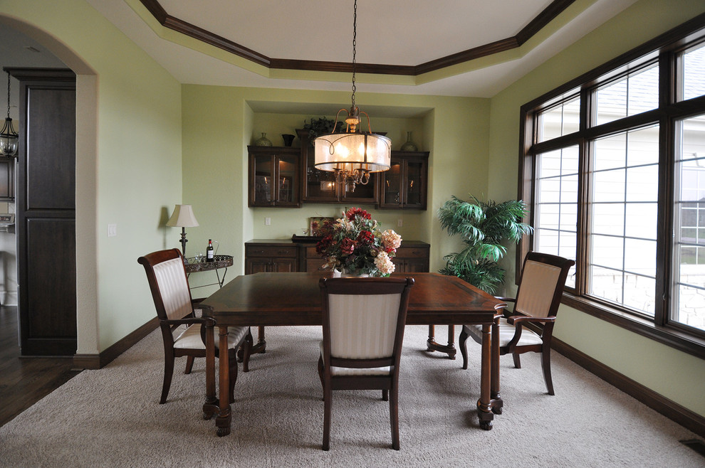 Large traditional open plan dining in Milwaukee with green walls and carpet.