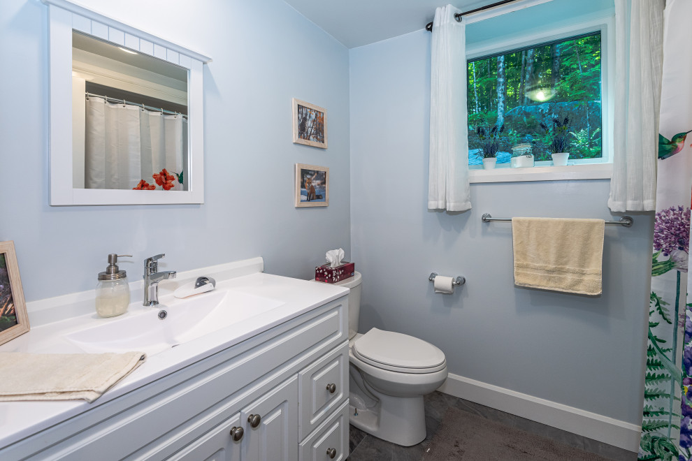 Exempel på ett mellanstort klassiskt grå grått badrum, med en toalettstol med hel cisternkåpa, blå väggar, vinylgolv, laminatbänkskiva, grått golv och dusch med skjutdörr