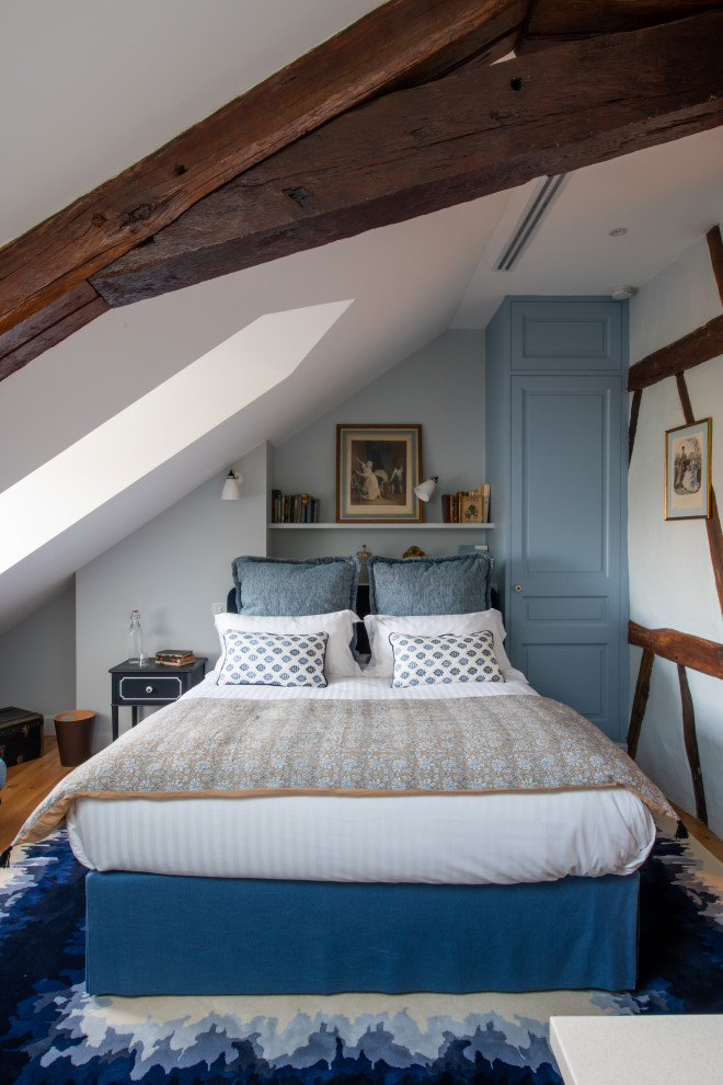 На фото: большая хозяйская спальня в стиле неоклассика (современная классика) с синими стенами, светлым паркетным полом и коричневым полом без камина