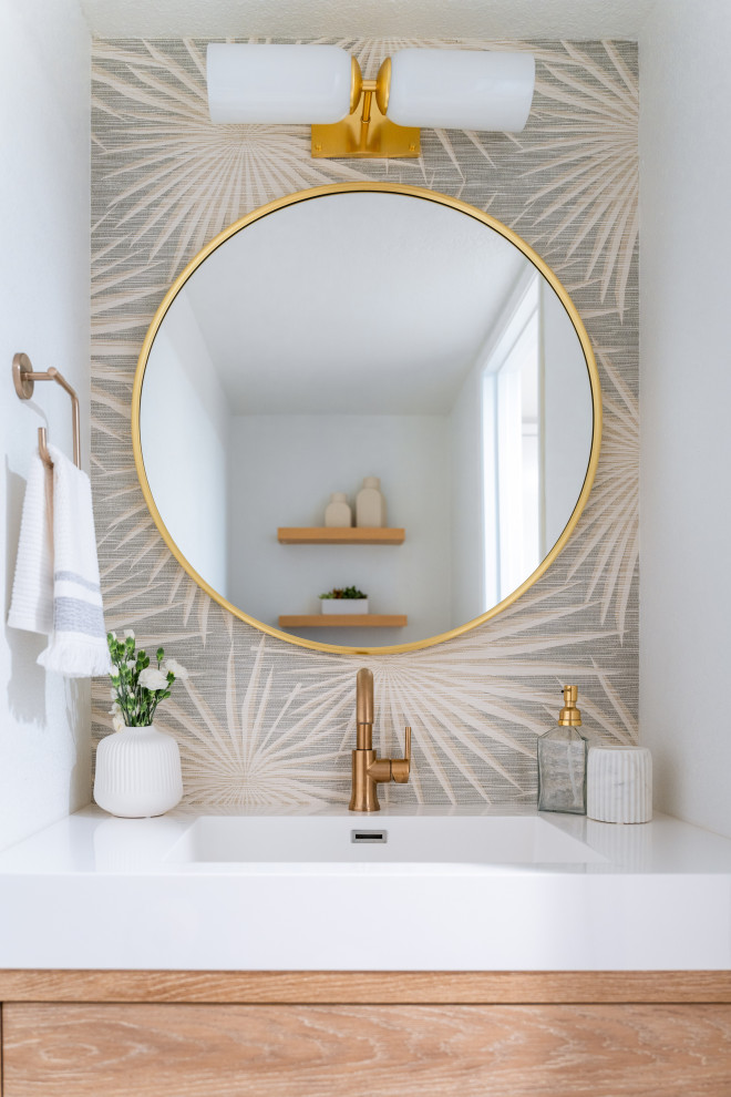 Inspiration for a small coastal wallpaper powder room remodel in San Diego with flat-panel cabinets, white walls, an integrated sink, solid surface countertops and a built-in vanity