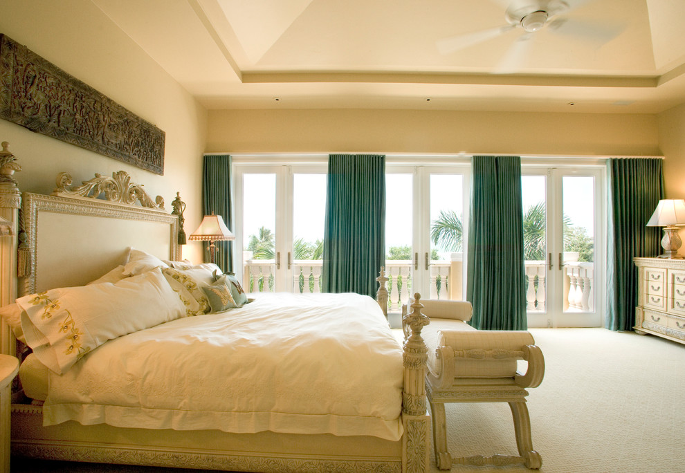 Design ideas for a mediterranean master bedroom in Miami with beige walls and carpet.