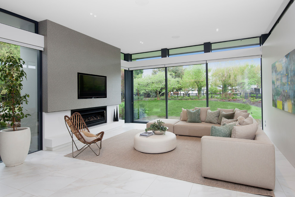 Photo of a large contemporary family room in Christchurch with grey walls, a ribbon fireplace, a wall-mounted tv and white floor.