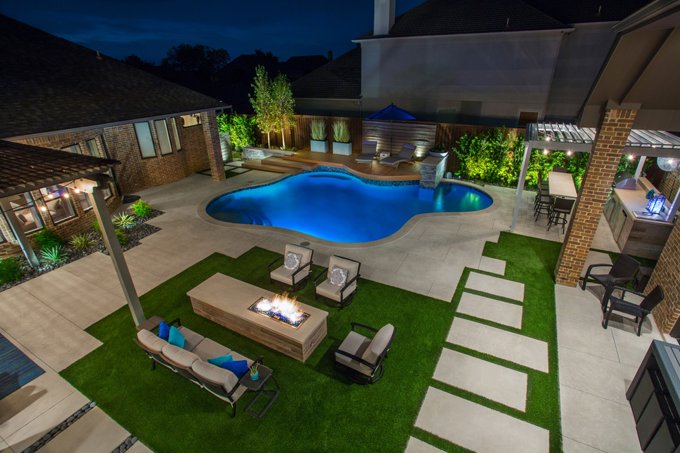 Photo of a mid-sized transitional side yard custom-shaped natural pool in Dallas with a water feature and concrete pavers.