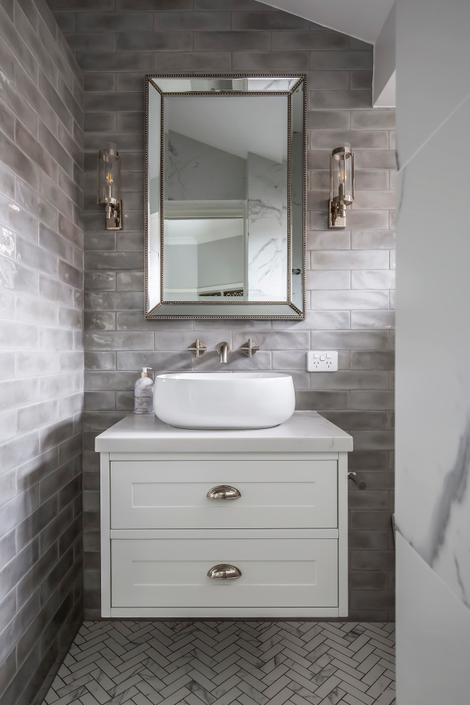 This is an example of a medium sized bathroom in Sydney with shaker cabinets, white cabinets, an alcove shower, a one-piece toilet, grey tiles, metro tiles, grey walls, marble flooring, a vessel sink, engineered stone worktops, multi-coloured floors, an open shower, white worktops, a single sink, a floating vanity unit and a vaulted ceiling.