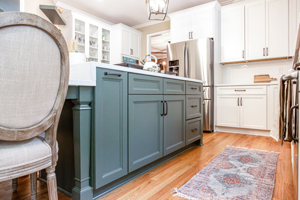 Example of a mid-sized transitional u-shaped light wood floor and beige floor open concept kitchen design in Atlanta with a farmhouse sink, shaker cabinets, white cabinets, quartz countertops, white backsplash, subway tile backsplash, stainless steel appliances, two islands and white countertops