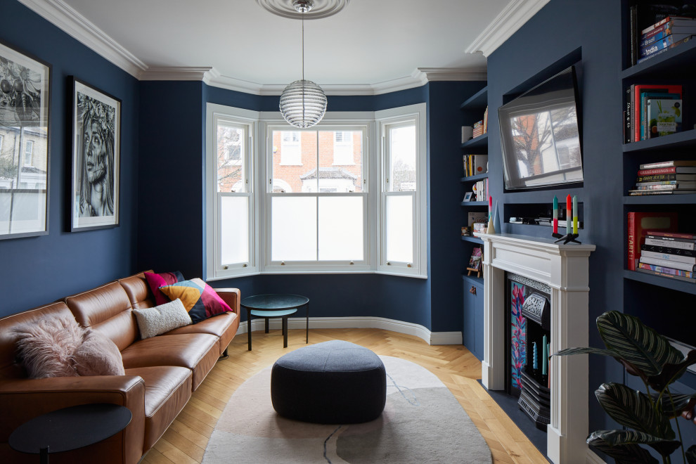 Mittelgroßes, Offenes Klassisches Musikzimmer mit blauer Wandfarbe, hellem Holzboden, Kamin, verputzter Kaminumrandung, TV-Wand und braunem Boden in London