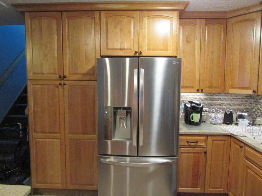 Inspiration for a mid-sized transitional l-shaped ceramic tile home design remodel with a double-bowl sink, raised-panel cabinets, light wood cabinets, quartz countertops, multicolored backsplash, mosaic tile backsplash, stainless steel appliances and an island