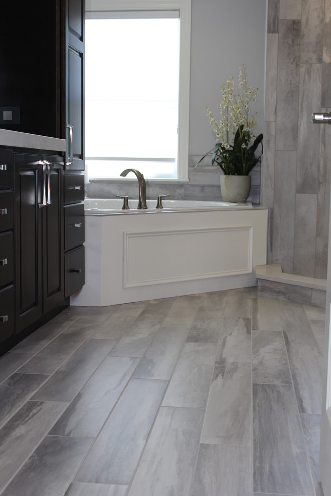 Corner bathtub - mid-sized modern master gray tile and porcelain tile porcelain tile corner bathtub idea in Boston with raised-panel cabinets, dark wood cabinets, gray walls and quartz countertops