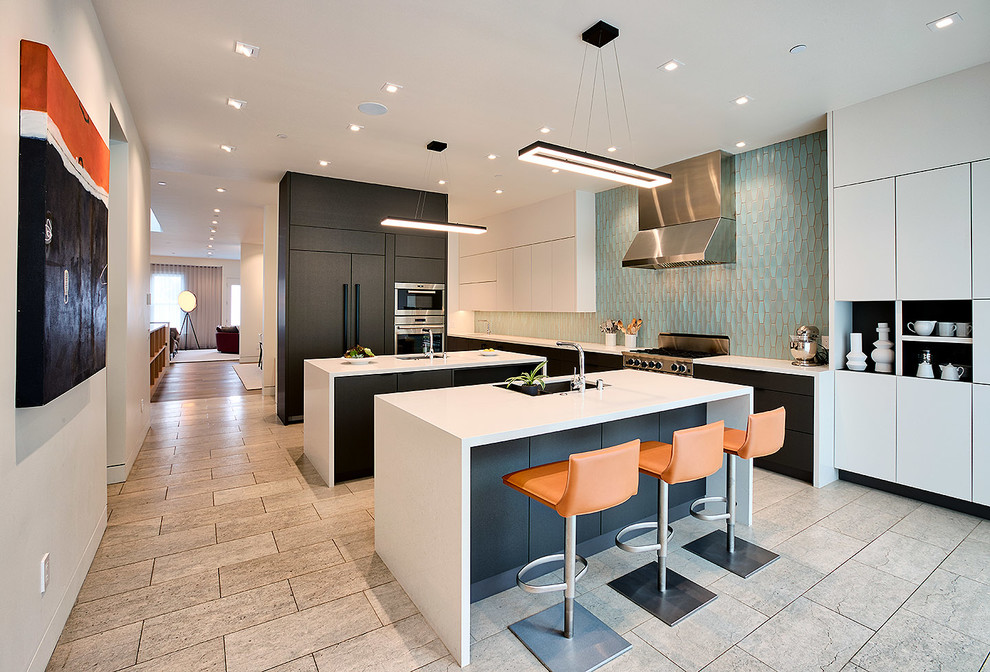 Photo of a large modern single-wall eat-in kitchen in San Francisco with an undermount sink, flat-panel cabinets, white cabinets, quartzite benchtops, blue splashback, glass tile splashback, stainless steel appliances, ceramic floors, multiple islands, multi-coloured floor and white benchtop.