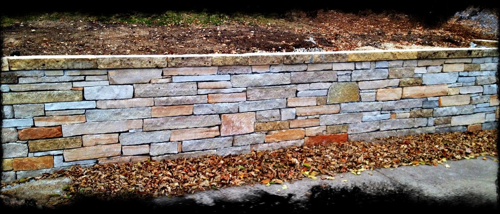 Mid-sized contemporary front yard garden in Minneapolis with a retaining wall and natural stone pavers.