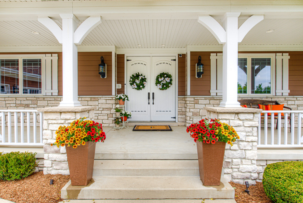 Mid-sized eclectic concrete paver metal railing front porch idea in Indianapolis with a roof extension