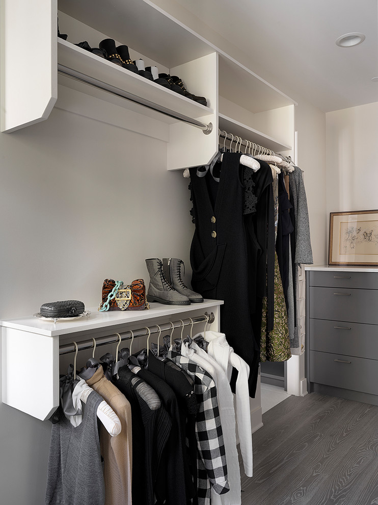 Photo of a scandinavian gender-neutral dressing room in Chicago with flat-panel cabinets, grey cabinets, medium hardwood floors and grey floor.