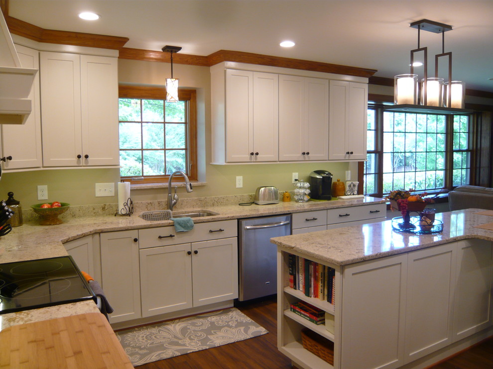 Photo of a mid-sized transitional u-shaped kitchen in DC Metro with an undermount sink, flat-panel cabinets, white cabinets, quartz benchtops, stainless steel appliances, medium hardwood floors and with island.