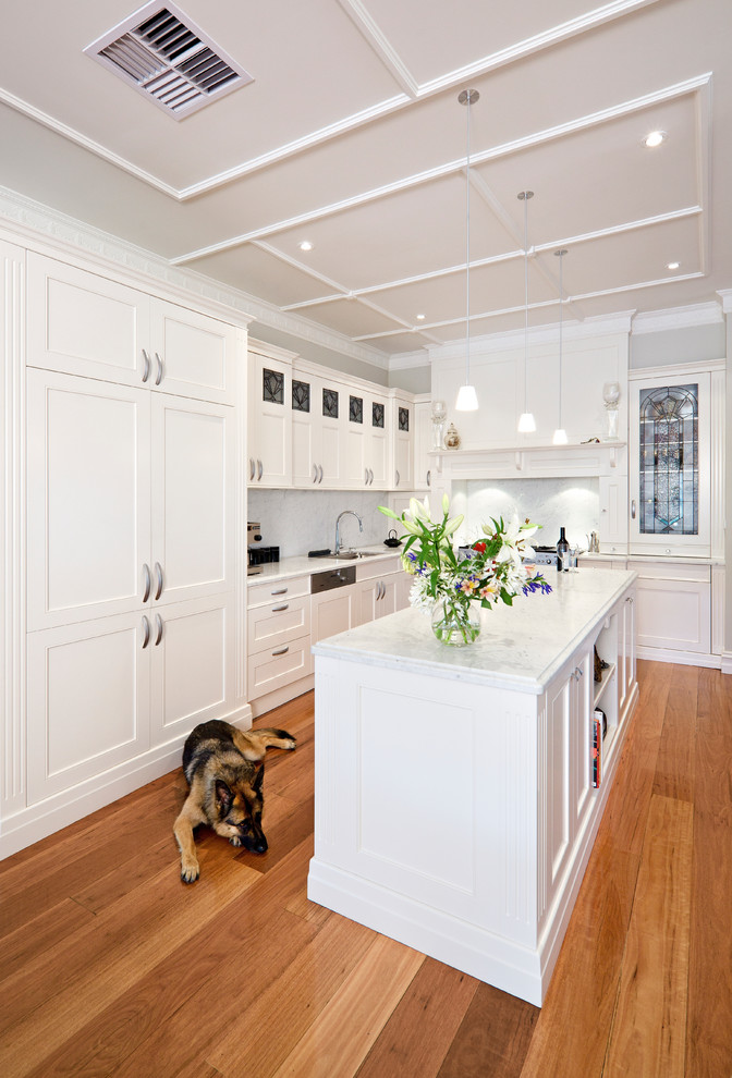 Design ideas for a traditional l-shaped separate kitchen in Melbourne with shaker cabinets, white cabinets, white splashback, panelled appliances, medium hardwood floors and with island.