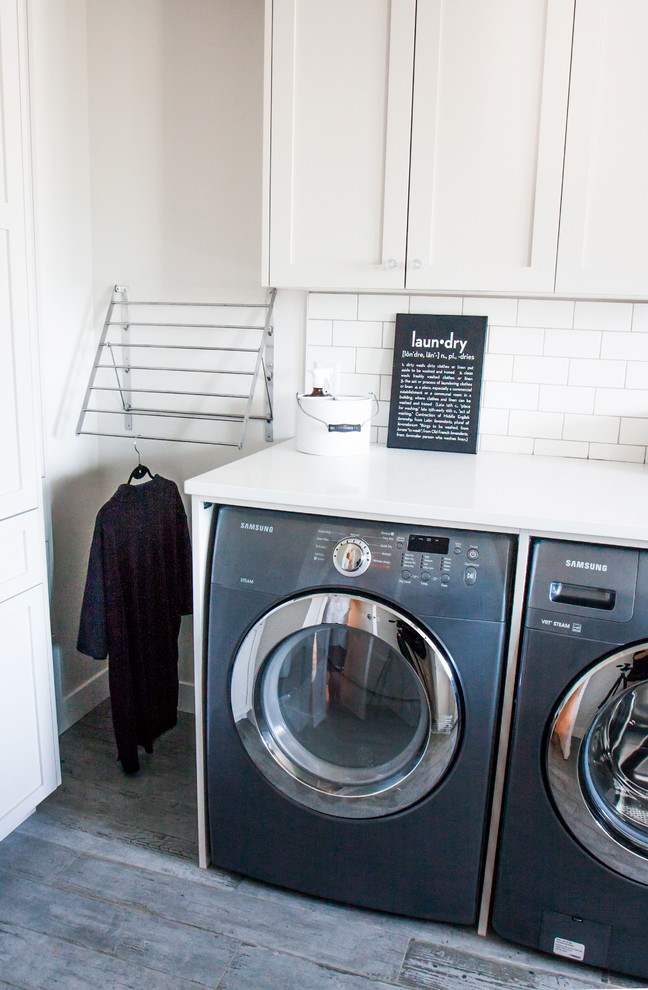 Photo of a mid-sized transitional laundry room in Vancouver with shaker cabinets, grey cabinets, quartz benchtops, porcelain floors and a side-by-side washer and dryer.