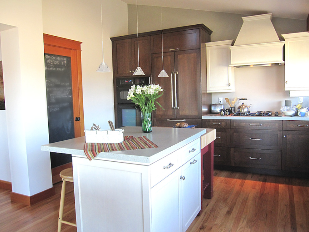 Eat-in kitchen - mid-sized traditional l-shaped medium tone wood floor eat-in kitchen idea in Seattle with a drop-in sink, shaker cabinets, medium tone wood cabinets, quartzite countertops, paneled appliances and an island