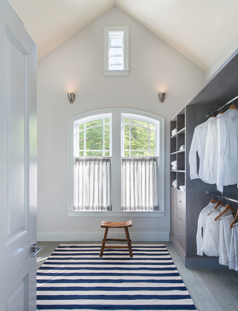 Large transitional gender-neutral walk-in wardrobe in Providence with flat-panel cabinets, grey cabinets, medium hardwood floors and grey floor.