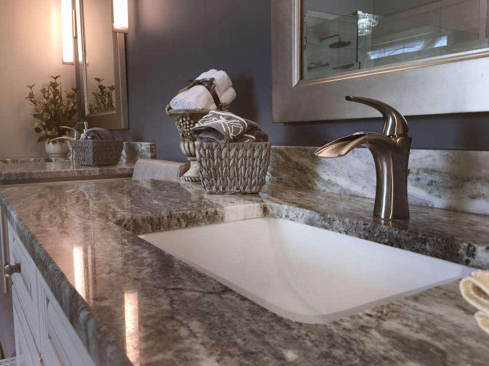 Large transitional master beige tile and ceramic tile porcelain tile and gray floor freestanding bathtub photo in Atlanta with recessed-panel cabinets, yellow cabinets, a two-piece toilet, blue walls, an undermount sink, granite countertops, a hinged shower door and multicolored countertops