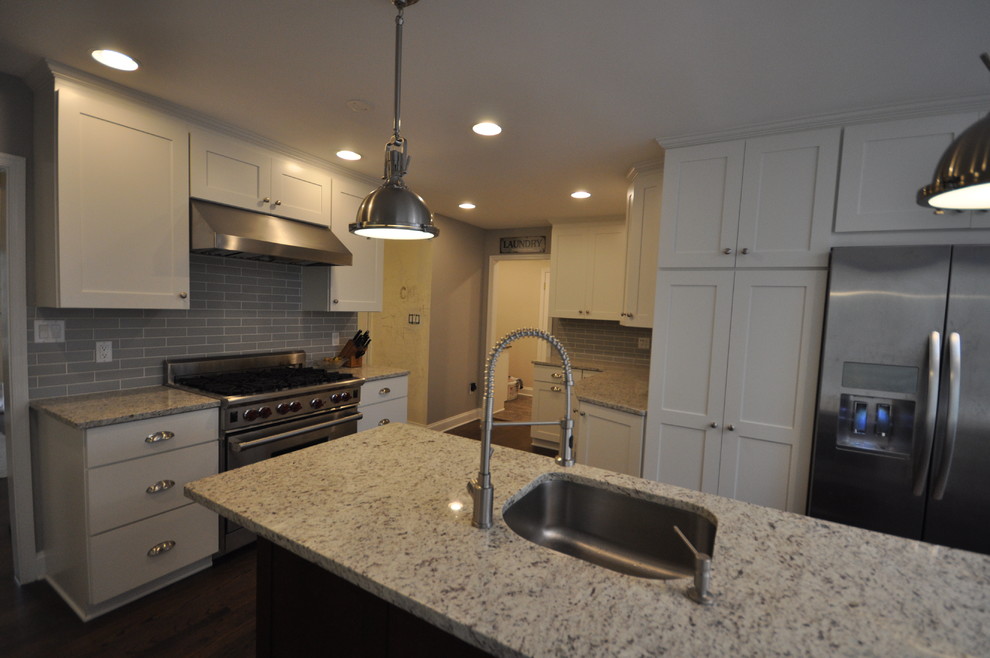 Example of a large transitional u-shaped dark wood floor and brown floor eat-in kitchen design in DC Metro with an undermount sink, shaker cabinets, white cabinets, green backsplash, subway tile backsplash, stainless steel appliances and an island