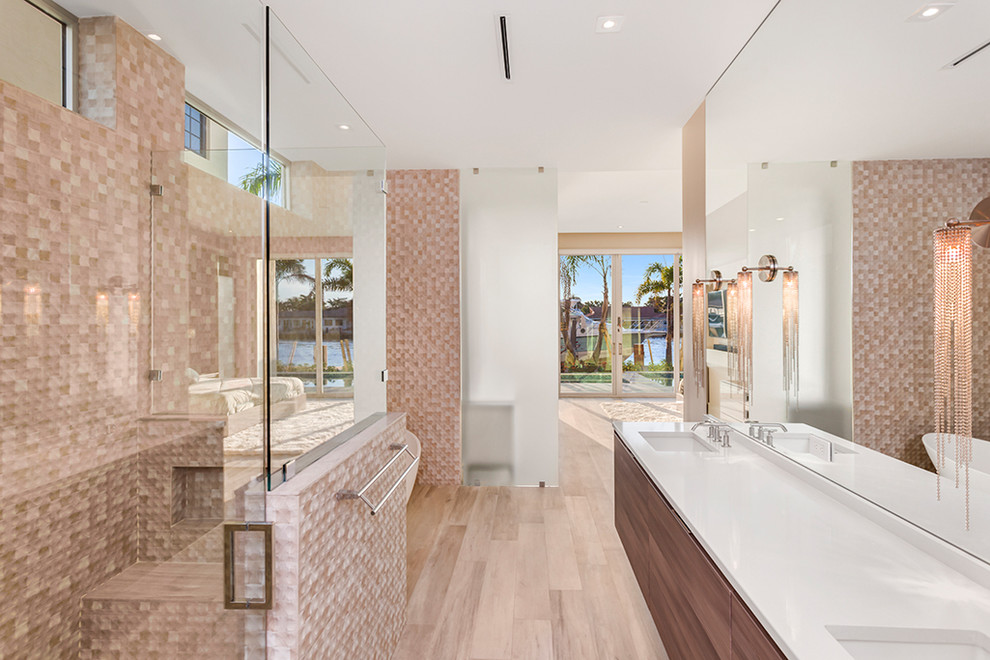 This is an example of a large contemporary master bathroom in Miami with a hinged shower door, flat-panel cabinets, dark wood cabinets, beige tile, multi-coloured tile, mosaic tile, white walls, light hardwood floors, an undermount sink, engineered quartz benchtops, beige floor and white benchtops.
