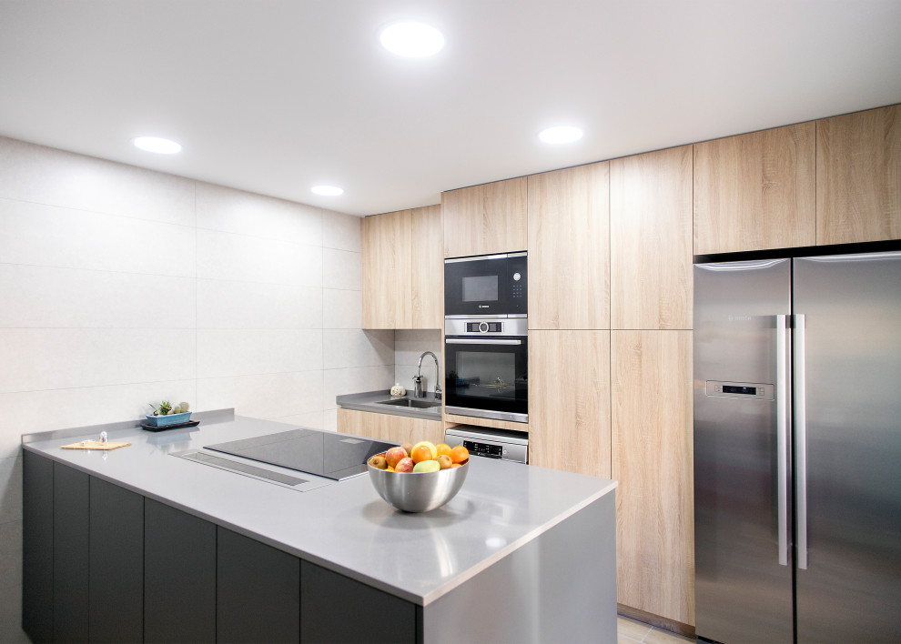 Design ideas for a large contemporary galley open plan kitchen in Barcelona with a single-bowl sink, flat-panel cabinets, medium wood cabinets, white splashback, ceramic splashback, stainless steel appliances, ceramic floors, no island, brown floor and grey benchtop.