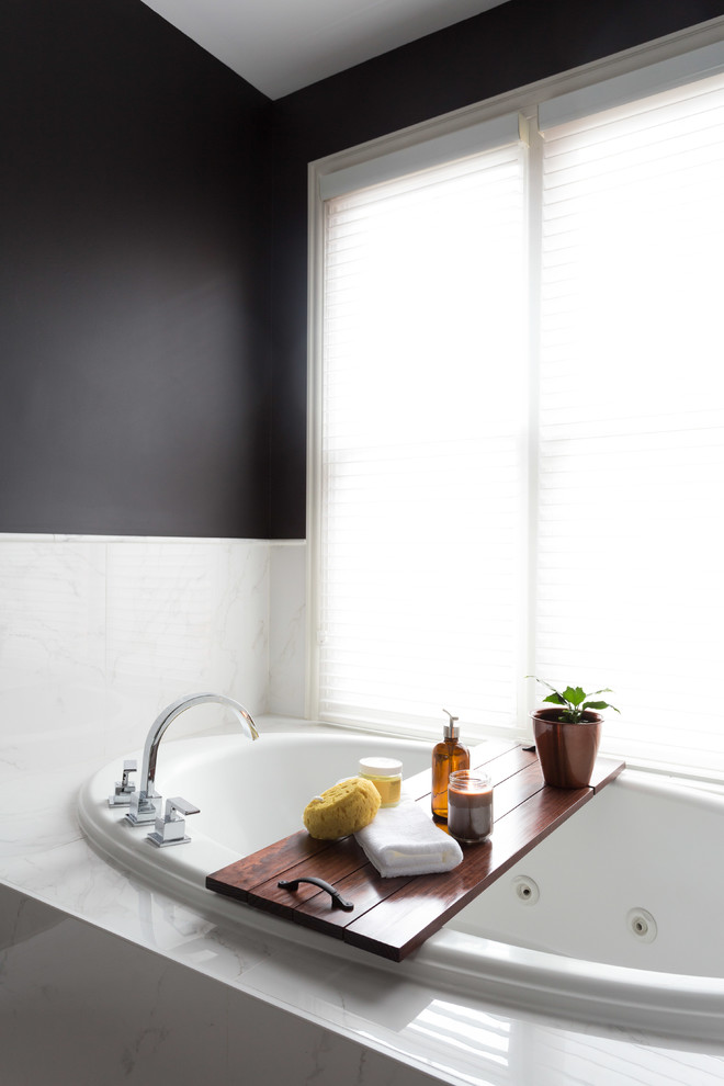 Design ideas for a mid-sized transitional master bathroom in Chicago with beaded inset cabinets, medium wood cabinets, a drop-in tub, an alcove shower, a one-piece toilet, black and white tile, porcelain tile, black walls, marble floors, an undermount sink and marble benchtops.