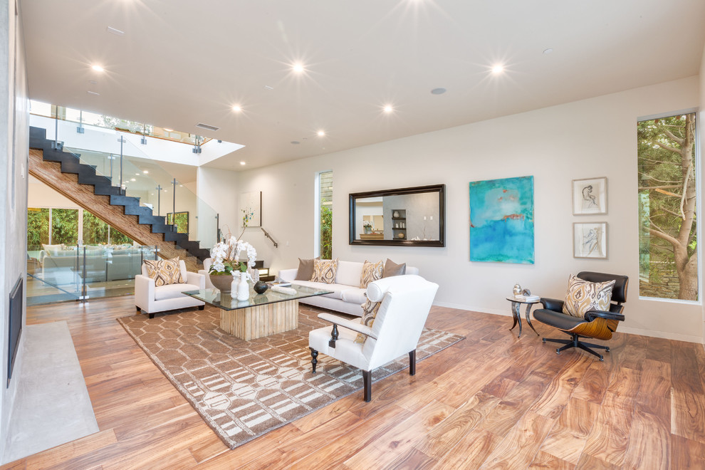 Large contemporary open concept living room in Los Angeles with white walls and medium hardwood floors.