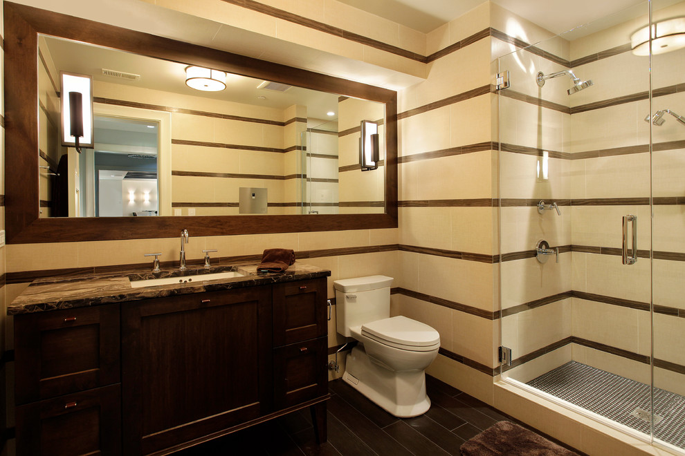 Photo of a transitional bathroom in Chicago with an undermount sink, dark wood cabinets, an alcove shower and beige tile.