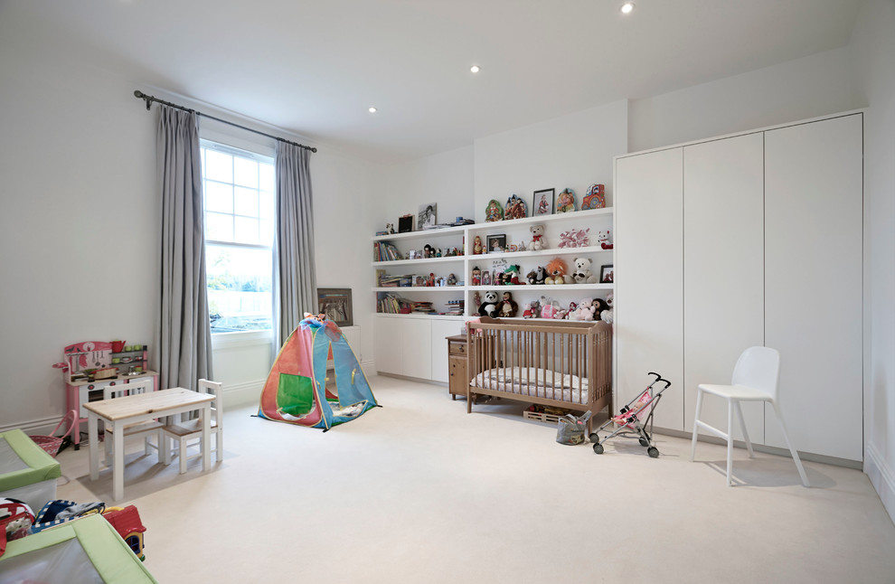 Large contemporary gender-neutral nursery in London with white walls and carpet.