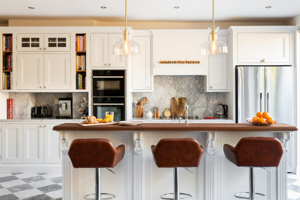 Inspiration for a mid-sized victorian single-wall eat-in kitchen remodel in London with shaker cabinets, white cabinets, quartzite countertops, gray backsplash, granite backsplash, stainless steel appliances, an island and gray countertops