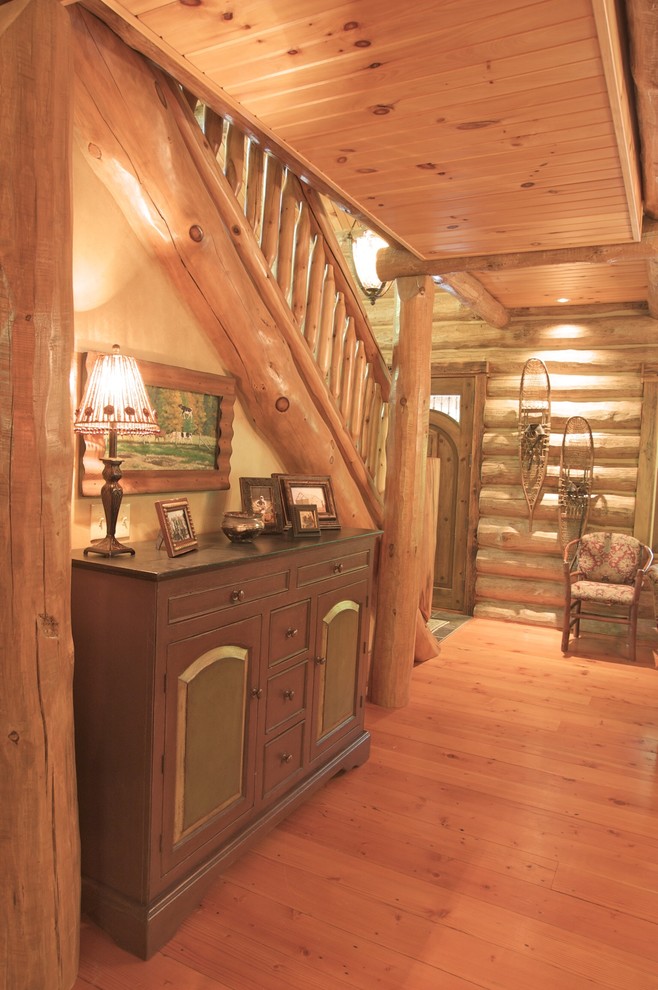 Example of a mid-sized mountain style medium tone wood floor entry hall design with brown walls and a medium wood front door