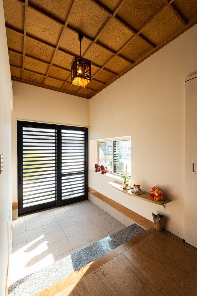 Photo of an asian entry hall in Other with white walls, a sliding front door and grey floor.