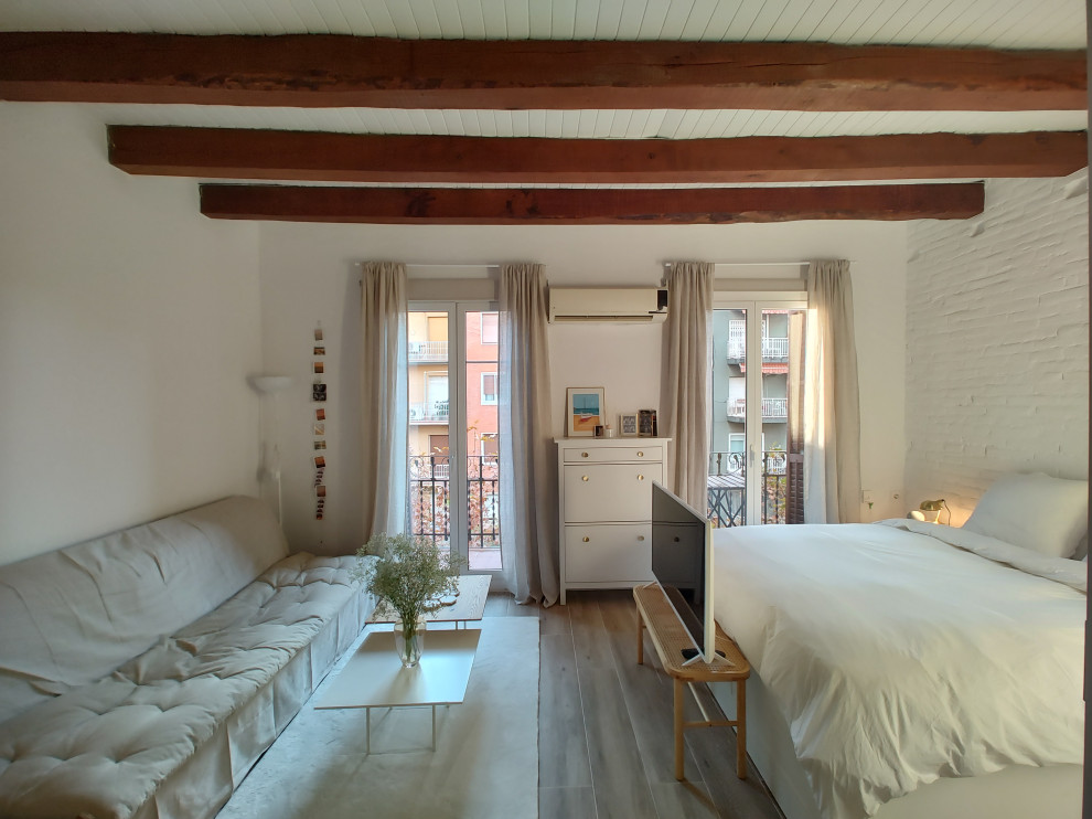 This is an example of a small scandi mezzanine living room in Barcelona with white walls, medium hardwood flooring, a freestanding tv, brown floors, a wood ceiling and brick walls.