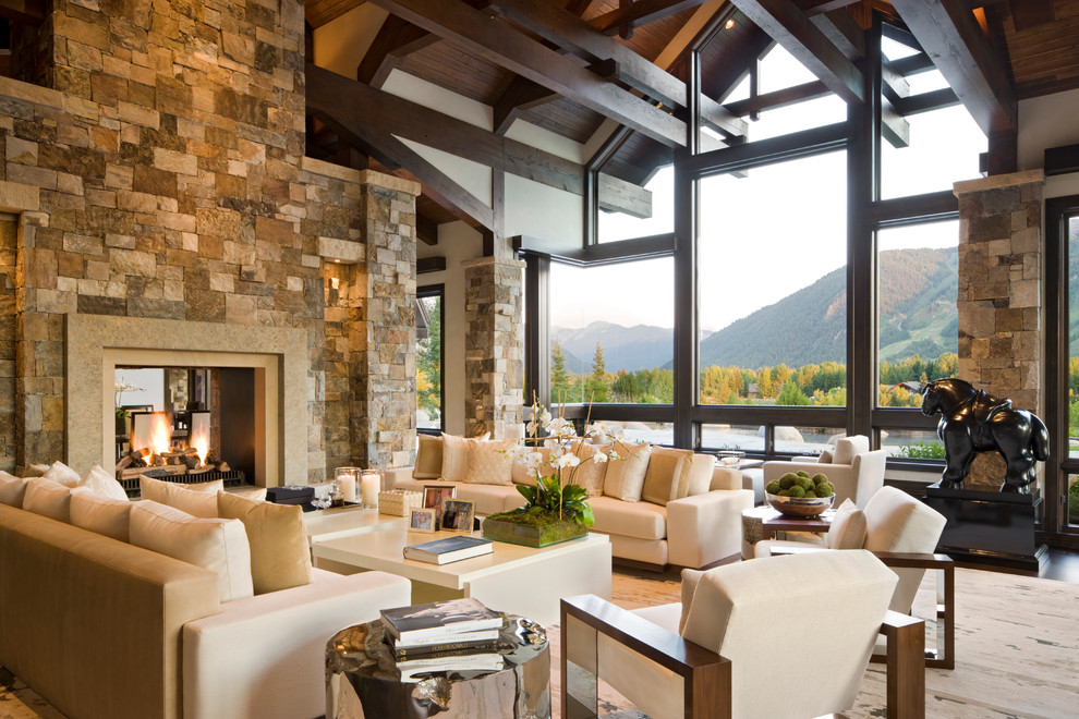 Photo of an expansive contemporary living room in Denver with a two-sided fireplace, a stone fireplace surround and no tv.