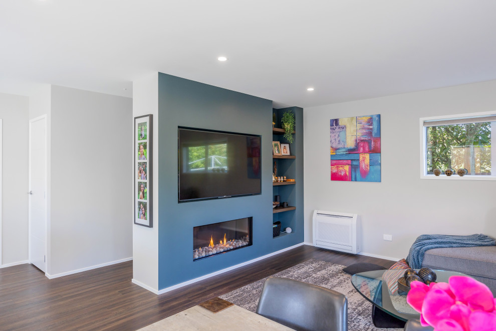 Kleines, Offenes Modernes Wohnzimmer mit grüner Wandfarbe, Vinylboden, Gaskamin, Multimediawand und braunem Boden in Auckland