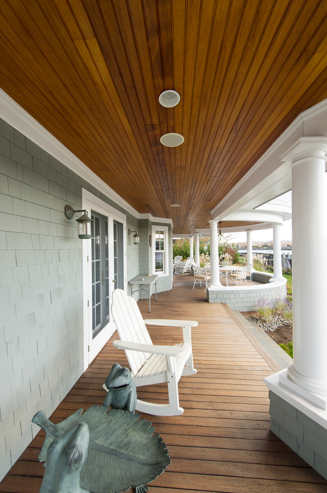 Inspiration for a large beach style side yard verandah in New York with a roof extension and decking.