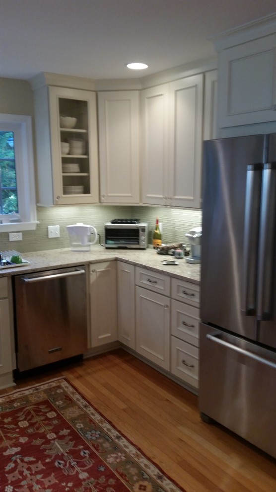 Transitional home design photo with flat-panel cabinets, white cabinets, quartz countertops and glass sheet backsplash