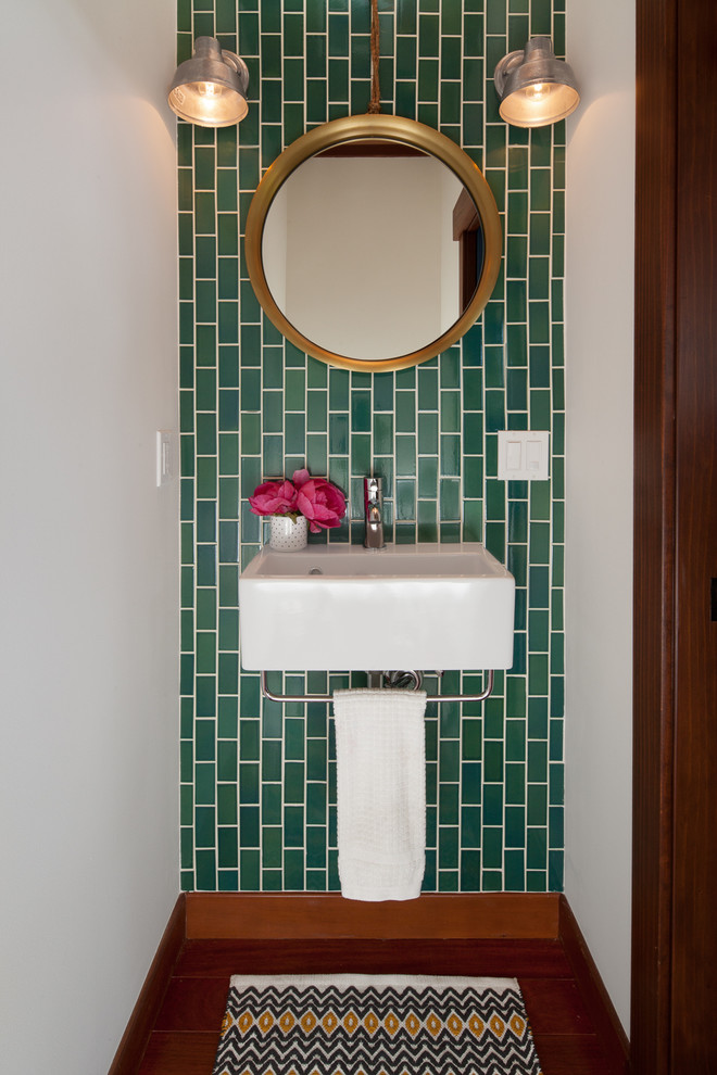 This is an example of a small eclectic powder room in San Francisco with white walls, dark hardwood floors, a wall-mount sink and brown floor.