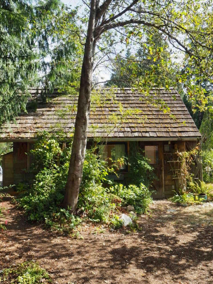 Idee per la micro casa piccola marrone rustica a un piano con rivestimento in legno, tetto a capanna, copertura a scandole, tetto marrone e pannelli sovrapposti