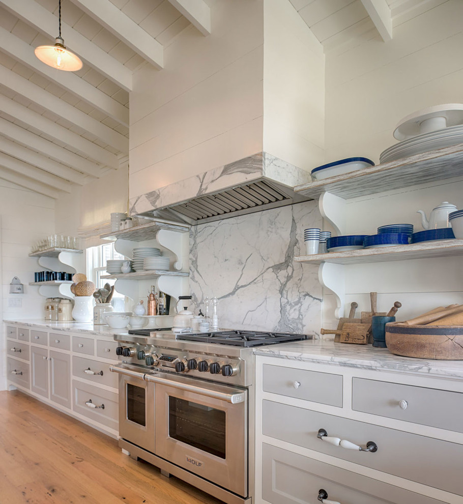 Design ideas for a beach style kitchen in Charleston with recessed-panel cabinets, grey cabinets, grey splashback, stone slab splashback, medium hardwood floors, brown floor and grey benchtop.