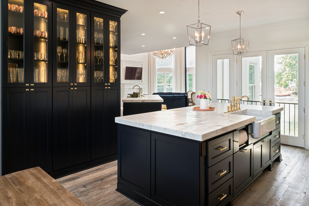 Large transitional l-shaped light wood floor eat-in kitchen photo in Charlotte with a farmhouse sink, recessed-panel cabinets, blue cabinets, marble countertops, white backsplash, subway tile backsplash, paneled appliances and two islands
