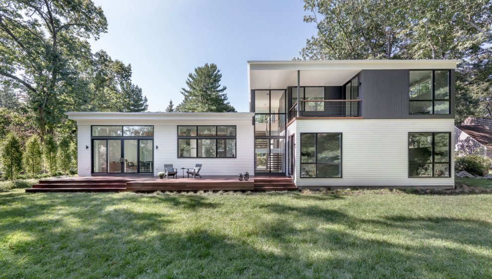Diseño de fachada de casa blanca y multicolor retro de tamaño medio de dos plantas con tejado plano