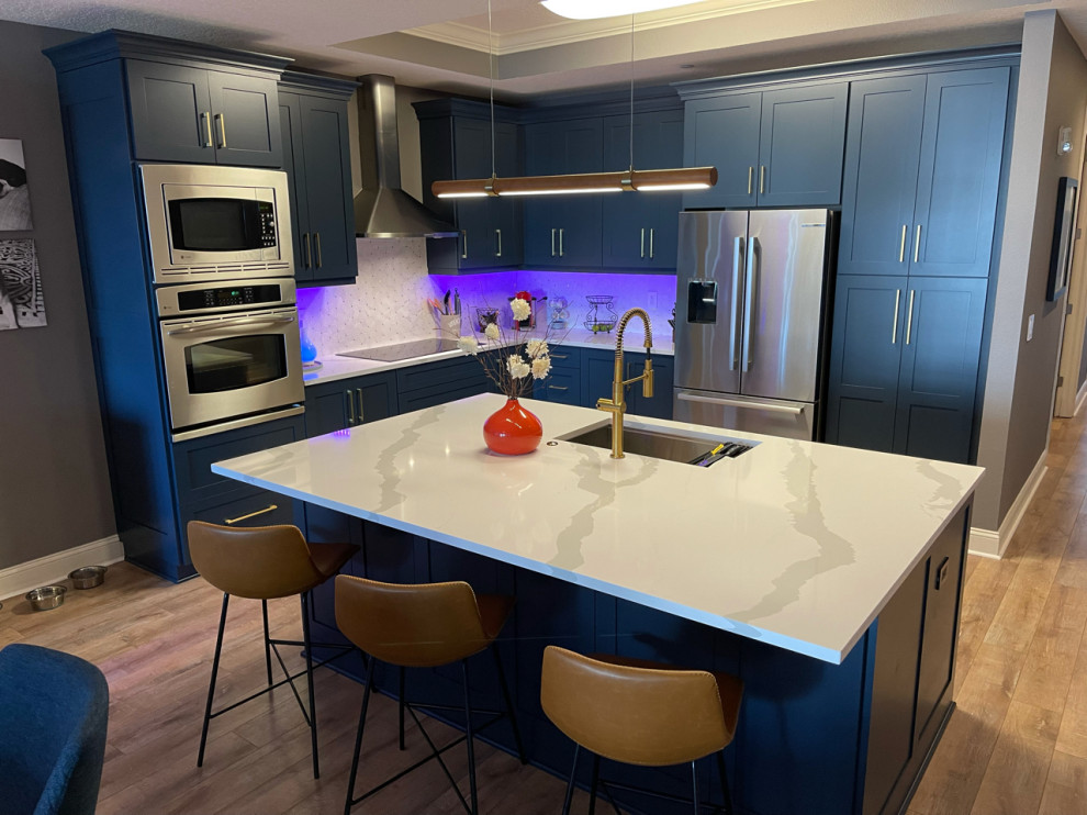 Photo of a medium sized traditional l-shaped kitchen/diner in Tampa with shaker cabinets, blue cabinets, white splashback and an island.
