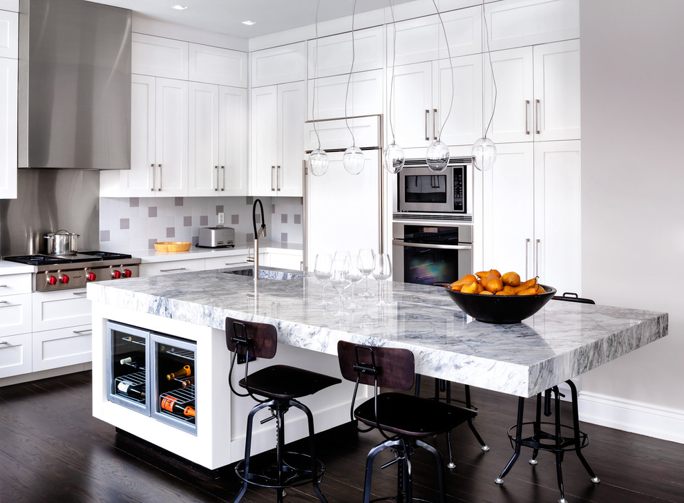 This is an example of a contemporary l-shaped kitchen in Toronto with an integrated sink, shaker cabinets, white cabinets, multi-coloured splashback, stainless steel appliances, dark hardwood floors and with island.